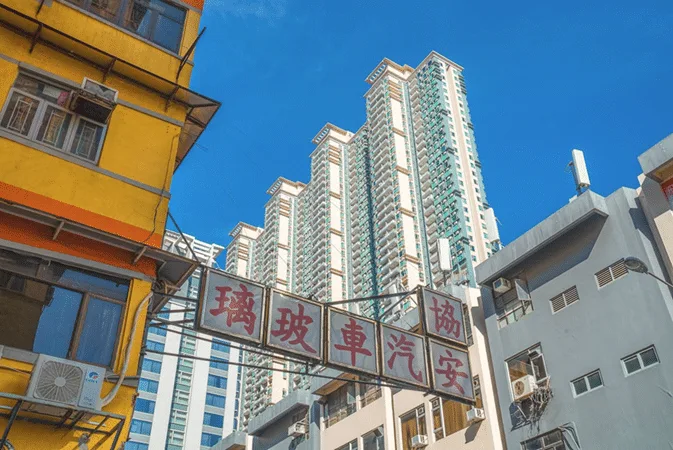Skyscrapers in Hong Kong under a blue sky, relating to international estate planning, wills, trusts, and cross-border matters.