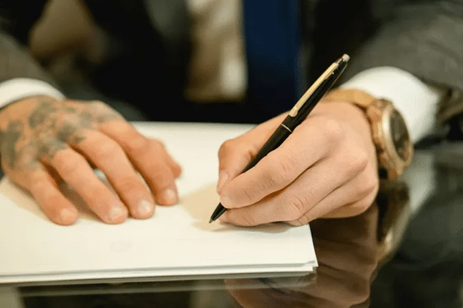 Man writing on paper, illustrating CRS Due Diligence responsibilities guide for financial institution compliance.
