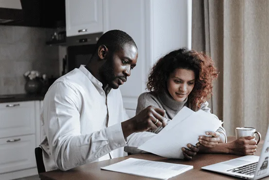 Couple reviews documents on Family Limited Partnerships for international estate planning at home.