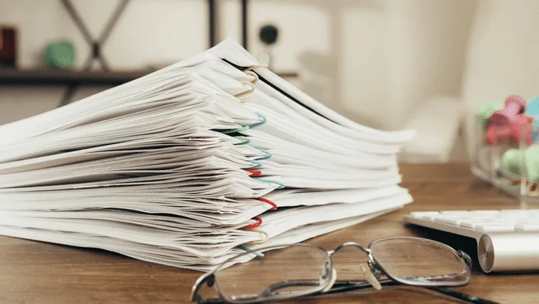 Stack of documents on CRS, highlighting its role in the automatic exchange of financial information for estate planning.
