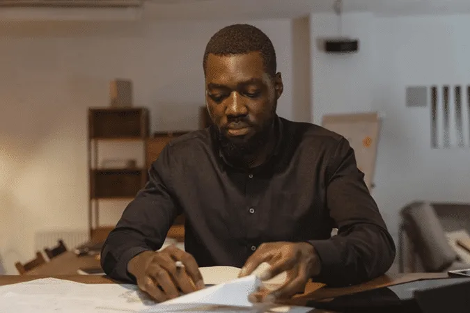 Man in office reviewing documents for international estate planning and life insurance guide.