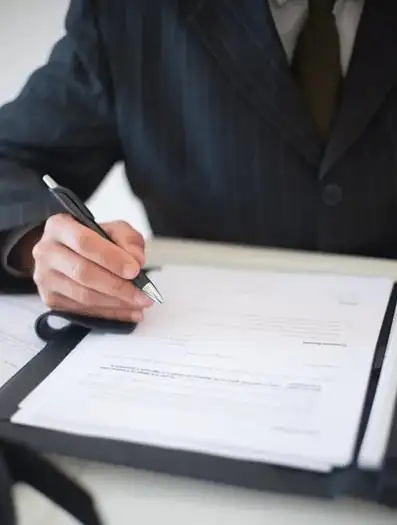 Person in a suit signing estate planning documents. Focus on non-charitable purpose trusts for international estates.