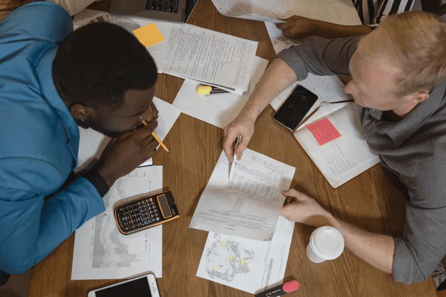 Two people review documents on dynasty trusts and international estate planning, comparing different jurisdictions.