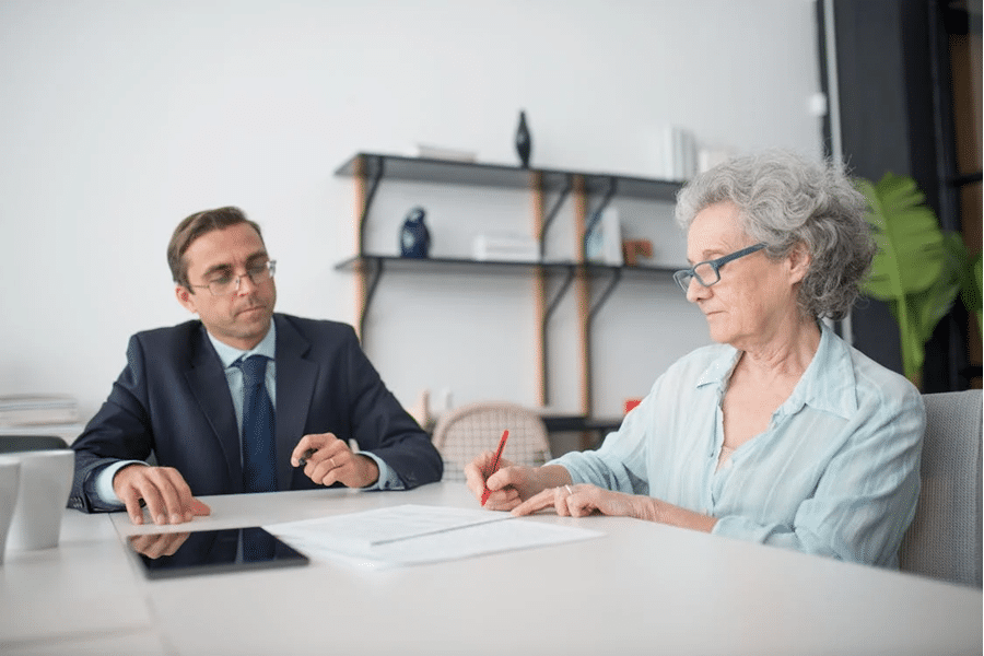 Two people discuss trust vs. foundation options for international estate planning, reviewing documents in an office.